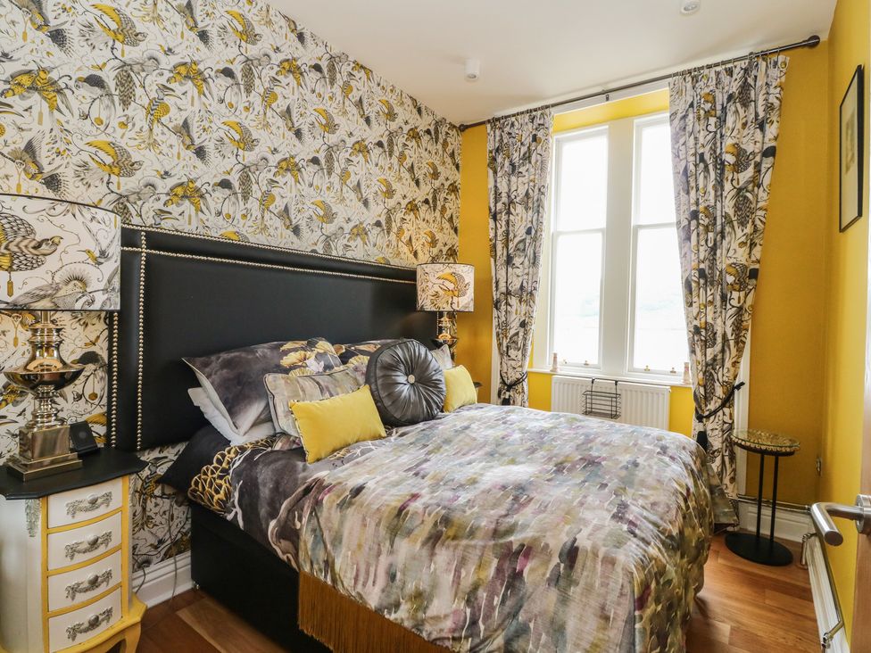 A bedroom with a bed and curtains at Heather Island View