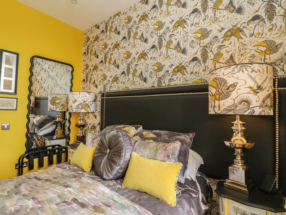 A bedroom with a bed and decorative wallpaper at Heather Island View