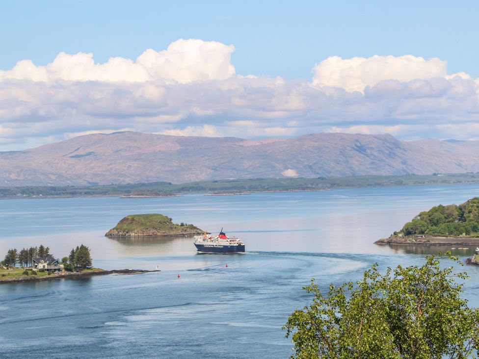 A view of a ship in the water with islands and mountains in the background at Heather Island View