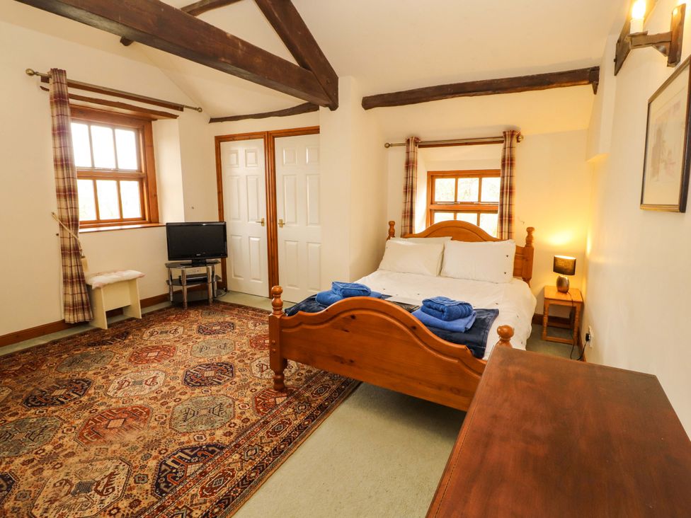 A bedroom with a bed and television at High Mill House Penrith