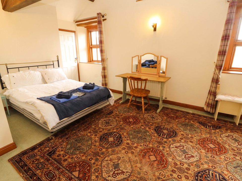 A bedroom with a bed and a vanity at High Mill House in Penrith