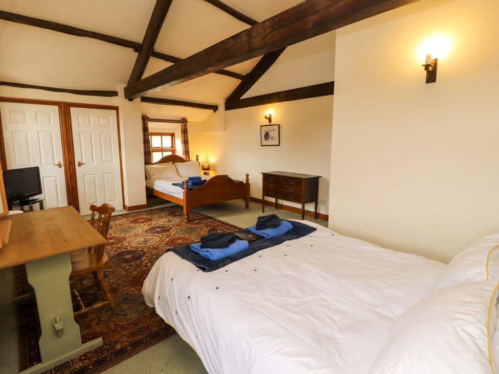 A bedroom with a bed and dresser at High Mill House in Penrith