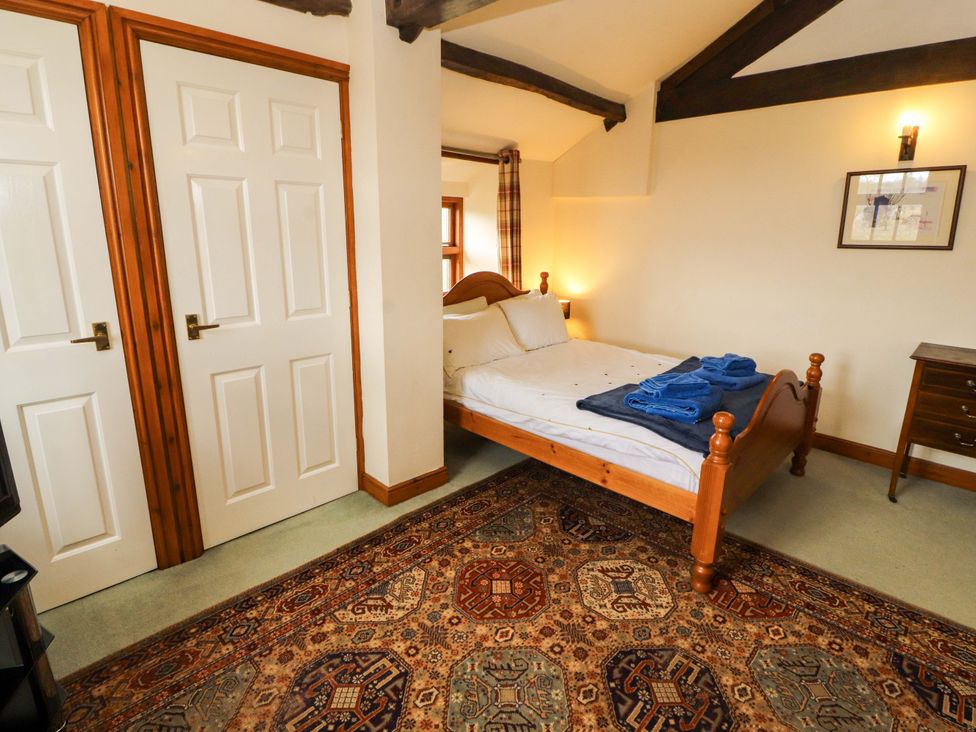 A bedroom with a bed and side table at High Mill House Penrith