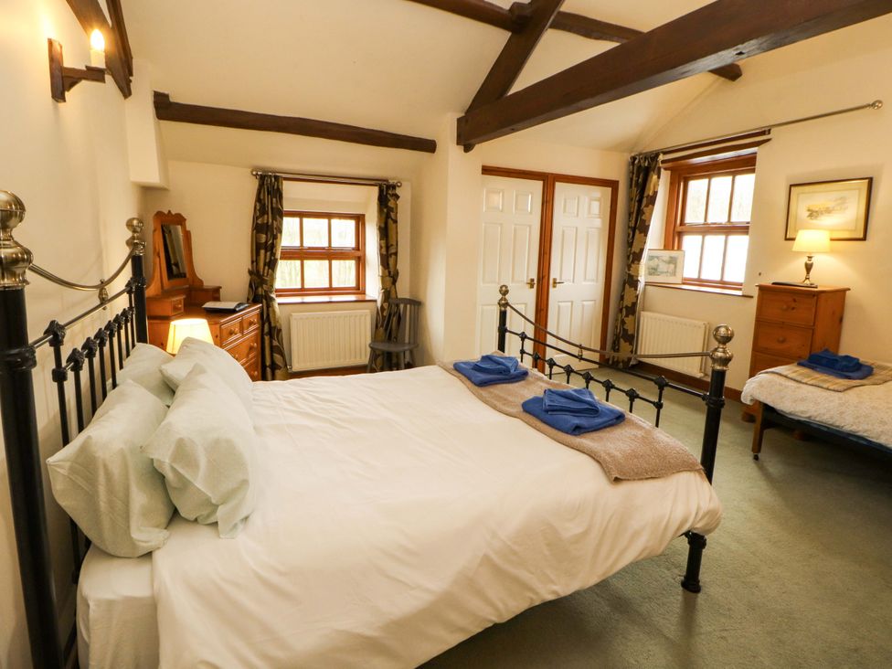 A bedroom with a bed and furniture at High Mill House Penrith