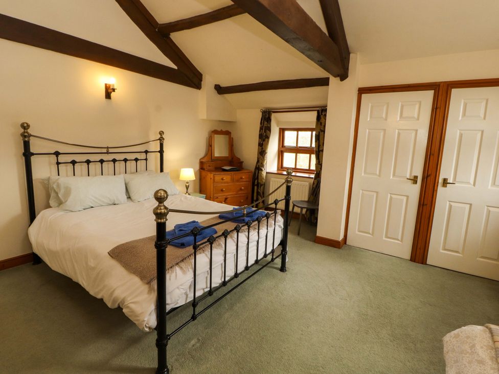 A bedroom featuring a bed with pillows and a nightstand at High Mill House Penrith