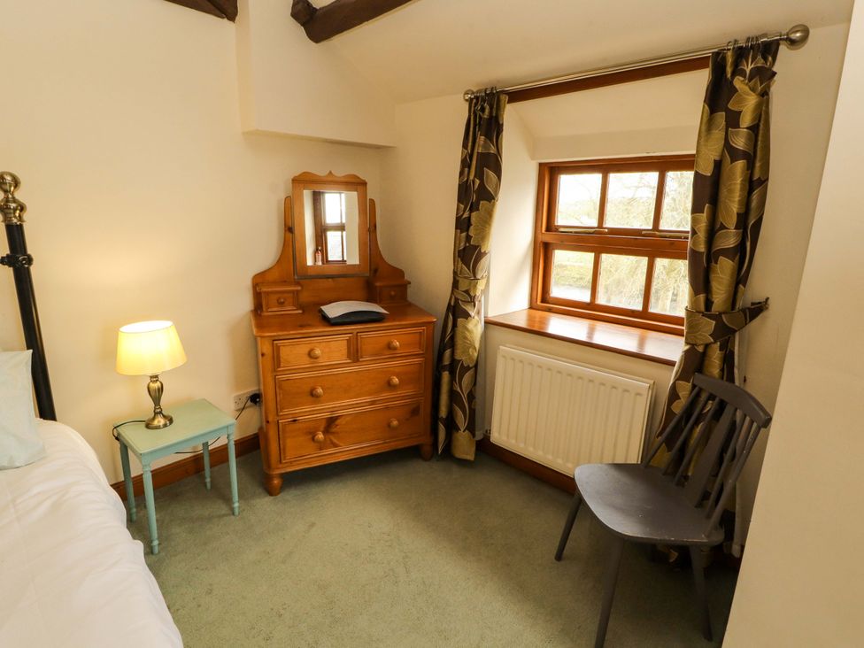 A bedroom with a dresser and lamp at High Mill House in Penrith