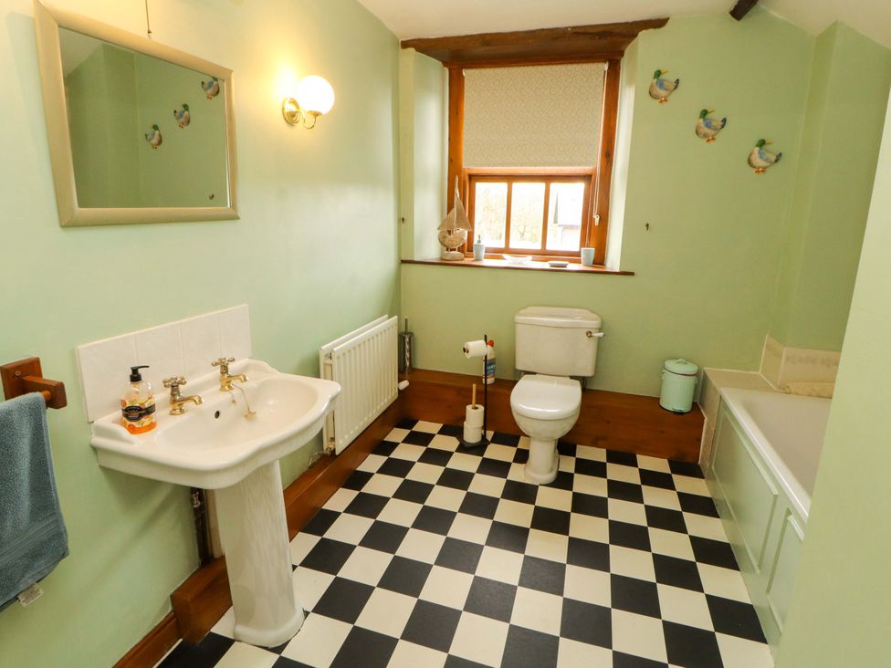 A bathroom with a sink, toilet, and bath at High Mill House Penrith