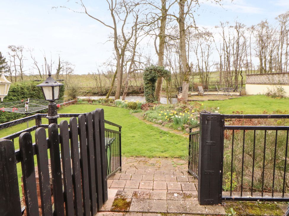 A garden view with a pathway and lamp post at High Mill House Penrith