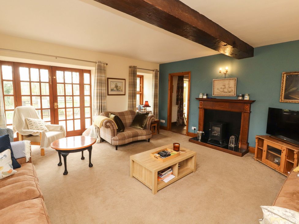 A living room with a fireplace and furniture at High Mill House in Penrith