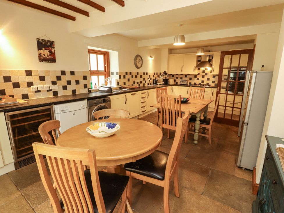 A kitchen with a table and chairs at High Mill House in Penrith