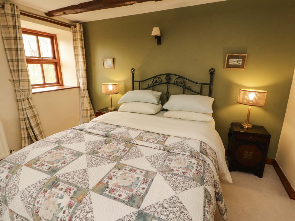 A bedroom with a bed and lamp at High Mill House in Penrith