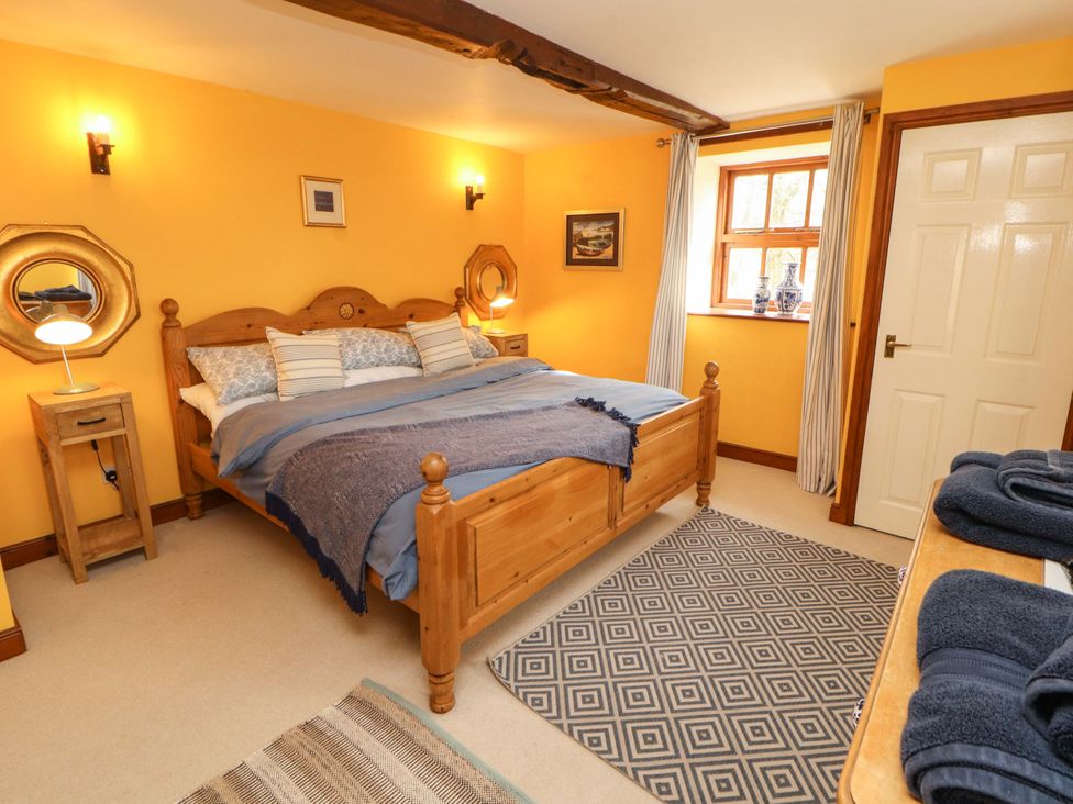 A bedroom with a bed and bedside table at High Mill House in Penrith