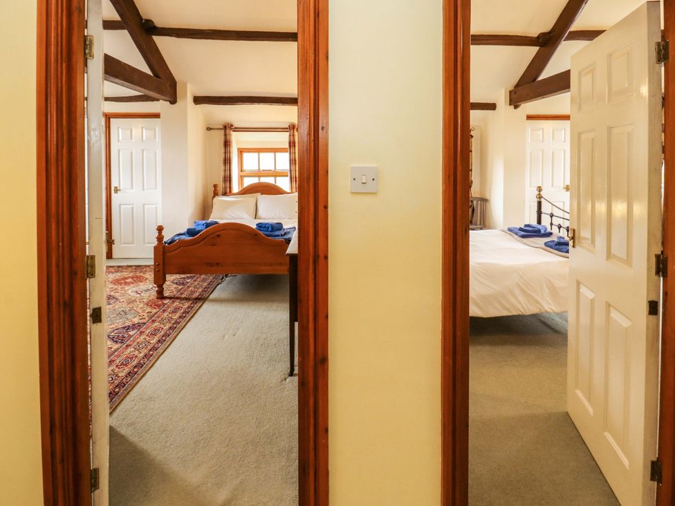 A bedroom with two beds and a doorway at High Mill House in Penrith