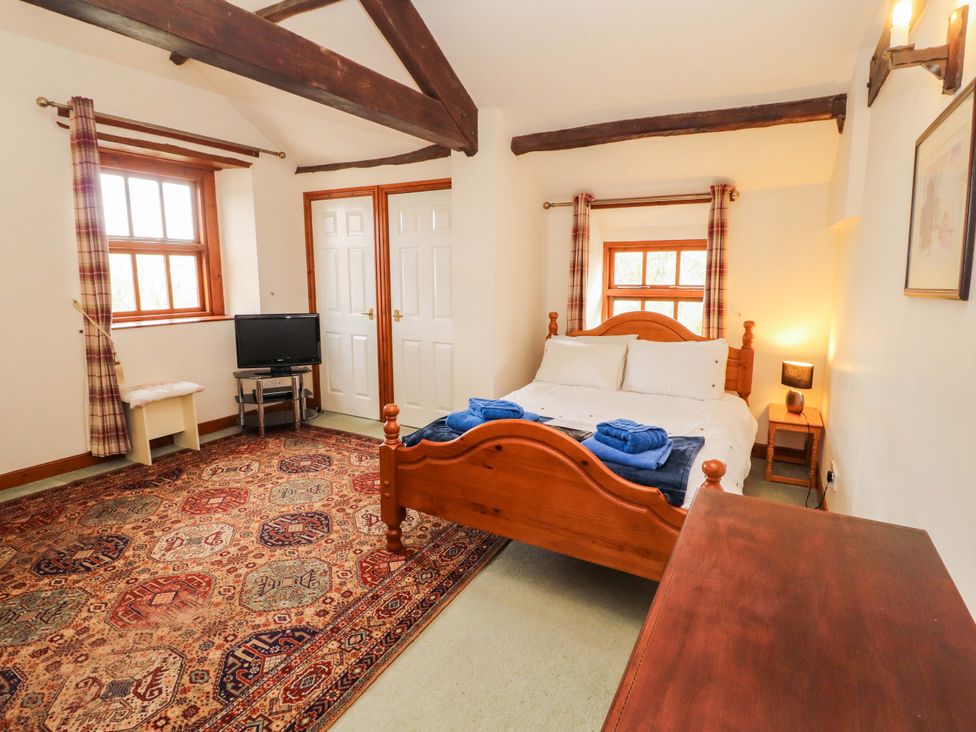 A bedroom with a bed and television at High Mill House in Penrith