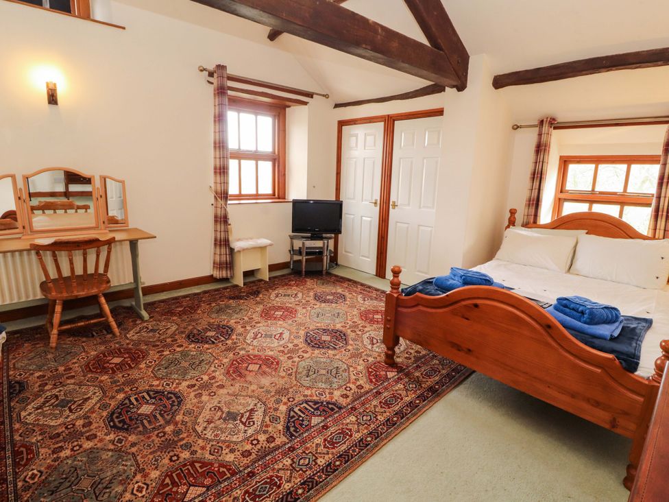 A bedroom with a bed and a dresser at High Mill House in Penrith