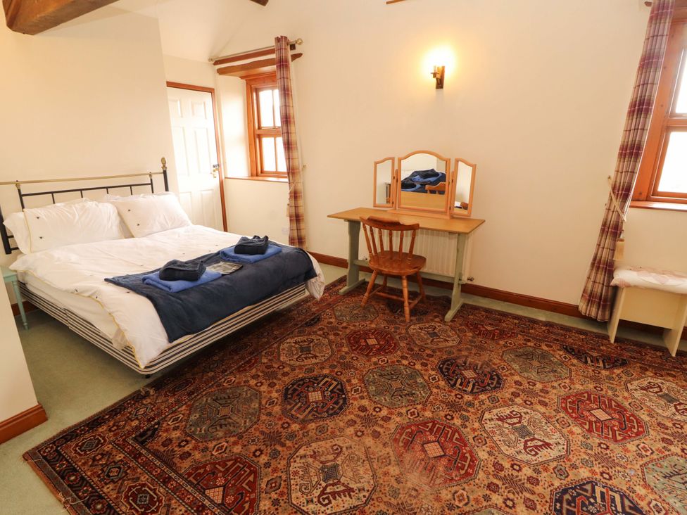 A bedroom with a bed and a mirror at High Mill House in Penrith