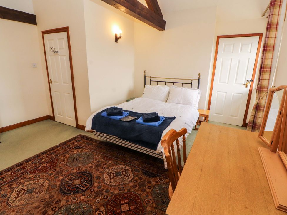 A bedroom with a bed and table at High Mill House in Penrith