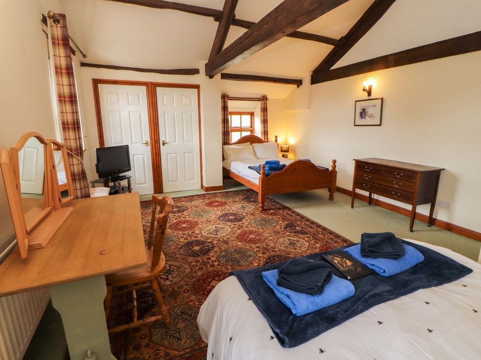 A bedroom with a bed and dresser at High Mill House in Penrith