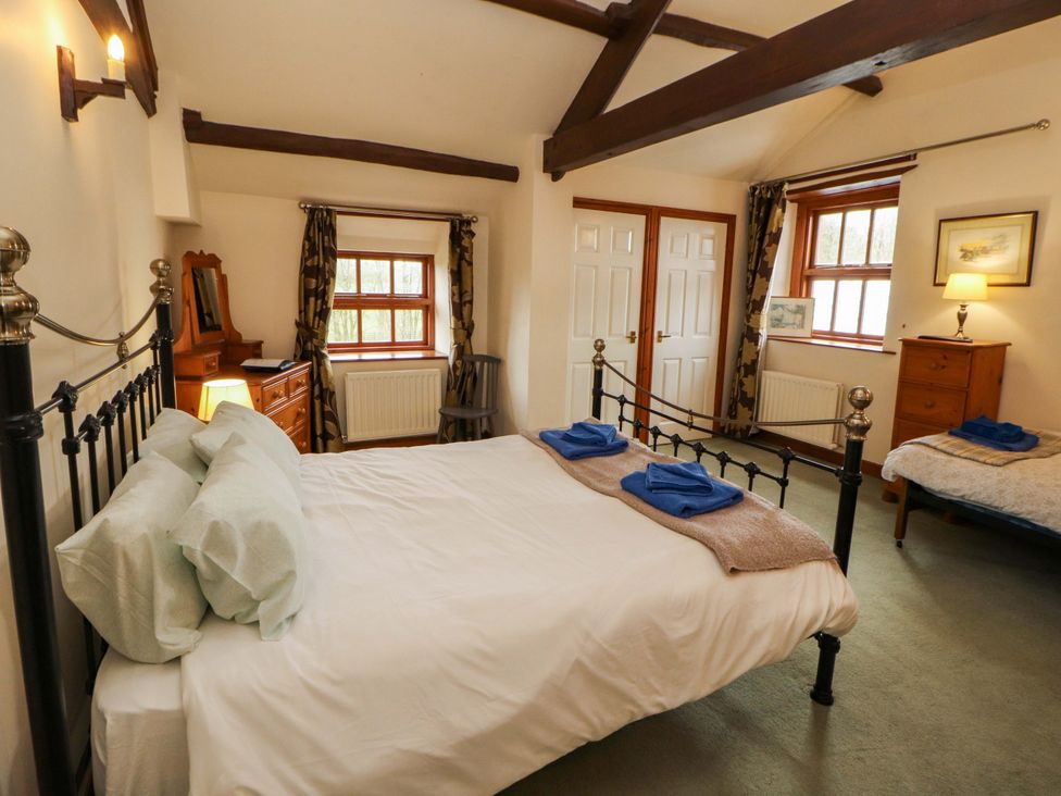 A bedroom with a bed and furniture at High Mill House in Penrith