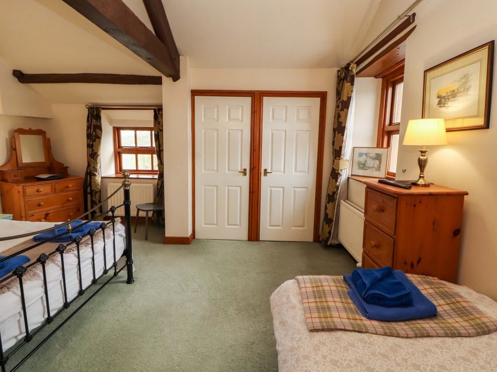 A bedroom with a bed and a dresser at High Mill House in Penrith