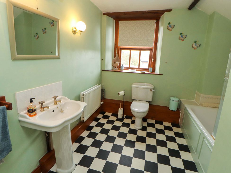 A bathroom with a sink, toilet, and tub at High Mill House in Penrith
