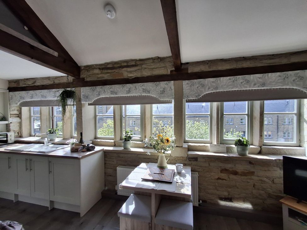 A kitchen with a table and chairs at Riverview Cottage in Holmfirth