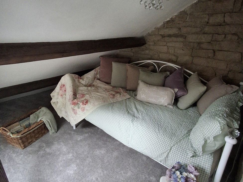 A bedroom with a bed and decorations at Riverview Cottage in Holmfirth