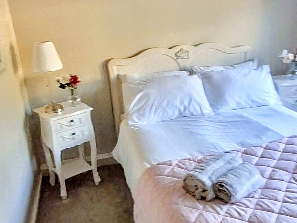 A bedroom with a bed and bedside table at Riverview Cottage in Holmfirth