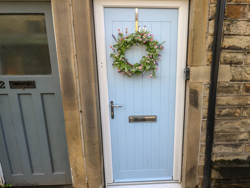 A blue front door with a wreath at Riverview Cottage in Holmfirth
