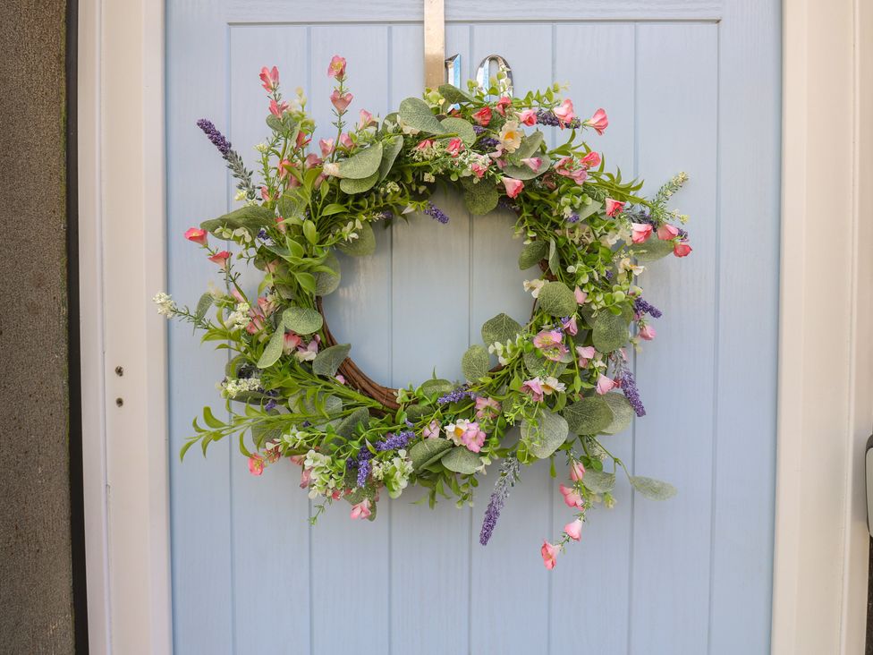 A wreath hanging on a blue door at Riverview Cottage in Holmfirth