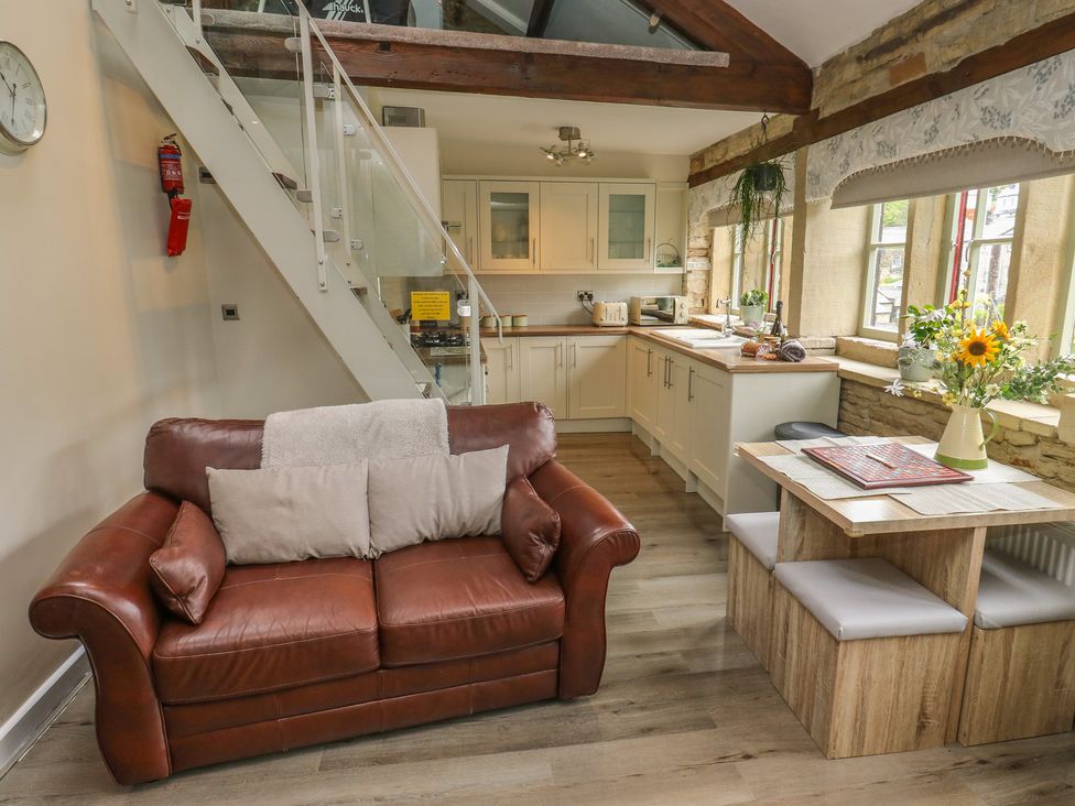 A kitchen with a sofa and dining area at Riverview Cottage in Holmfirth
