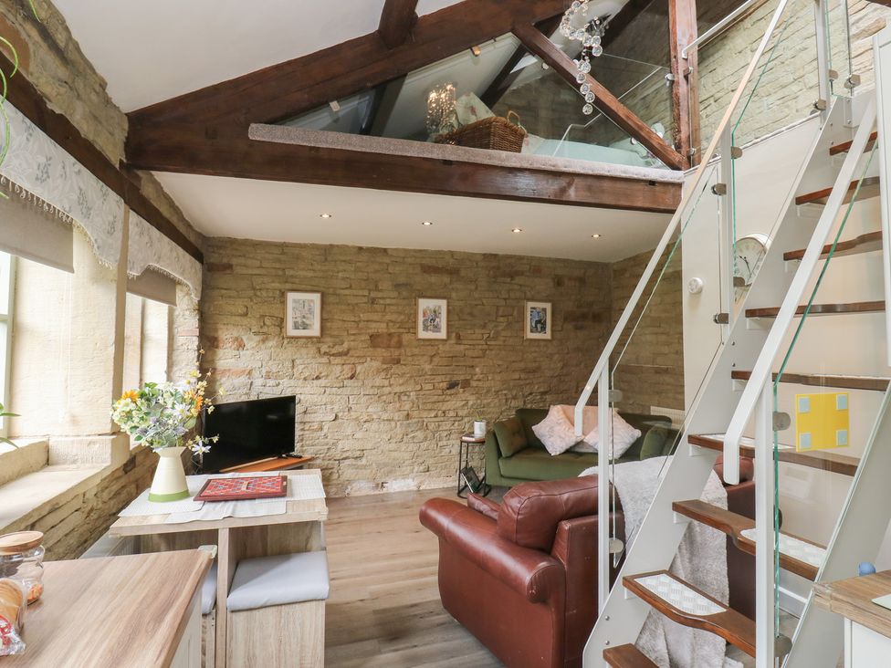 A living room with a sofa and table at Riverview Cottage in Holmfirth