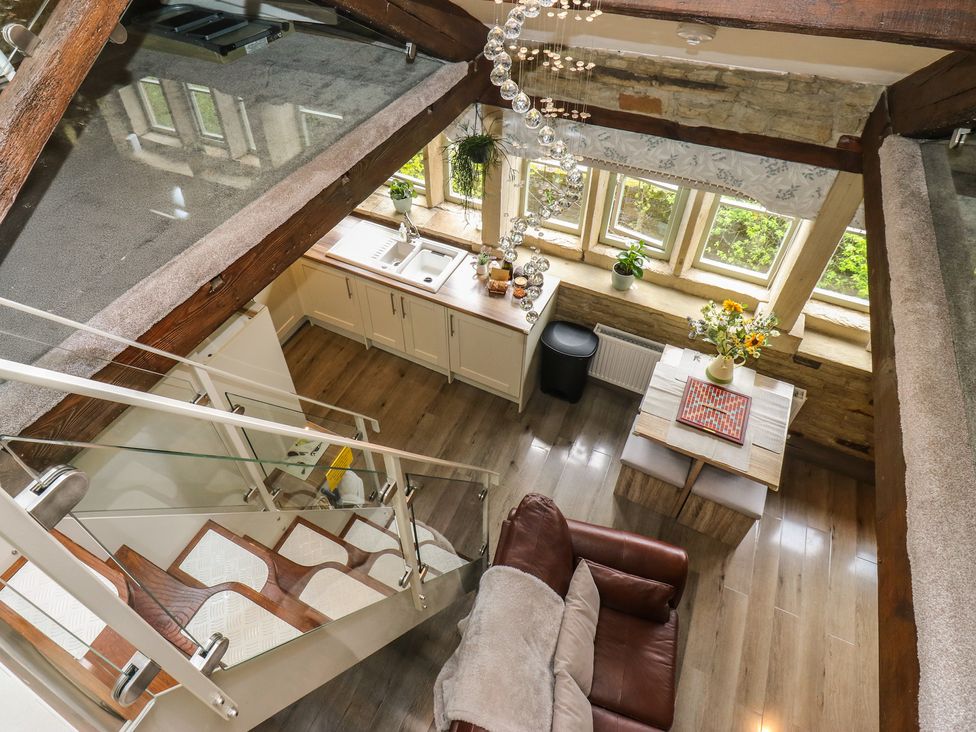 A living room with a kitchen and dining area at Riverview Cottage in Holmfirth