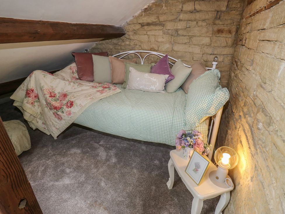 A bedroom with a daybed and side table at Riverview Cottage in Holmfirth