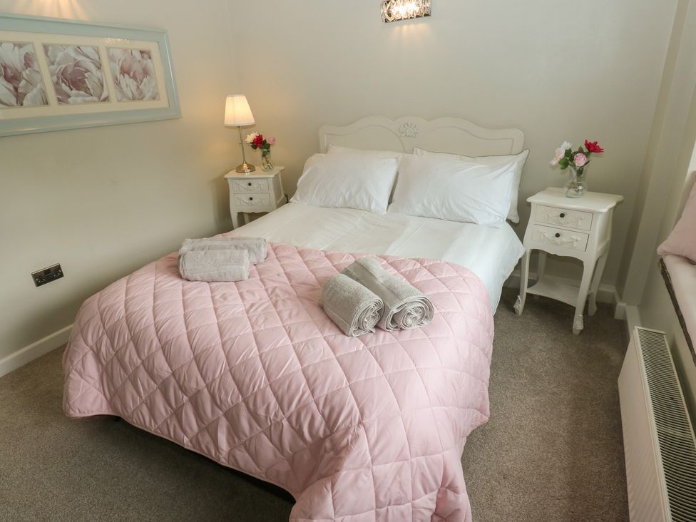 A bedroom with a bed and bedside tables at Riverview Cottage Holmfirth