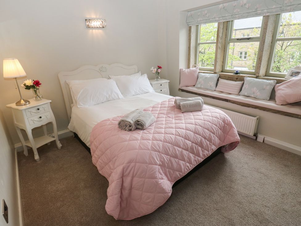A bedroom with a bed and bedside table at Riverview Cottage in Holmfirth