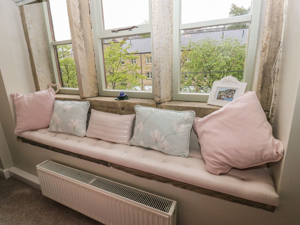 A window seat with cushions and radiator at Riverview Cottage in Holmfirth
