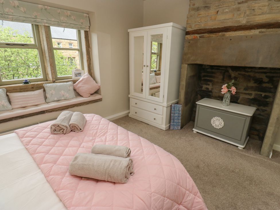 A bedroom with a bed and wardrobe at Riverview Cottage Holmfirth
