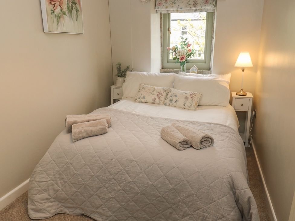 A bedroom with a bed and nightstand at Riverview Cottage in Holmfirth