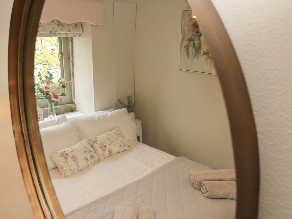 A bedroom with a bed and a window at Riverview Cottage Holmfirth