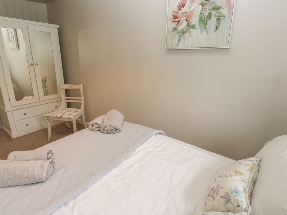 A bedroom featuring a bed and a dressing table at Riverview Cottage in Holmfirth