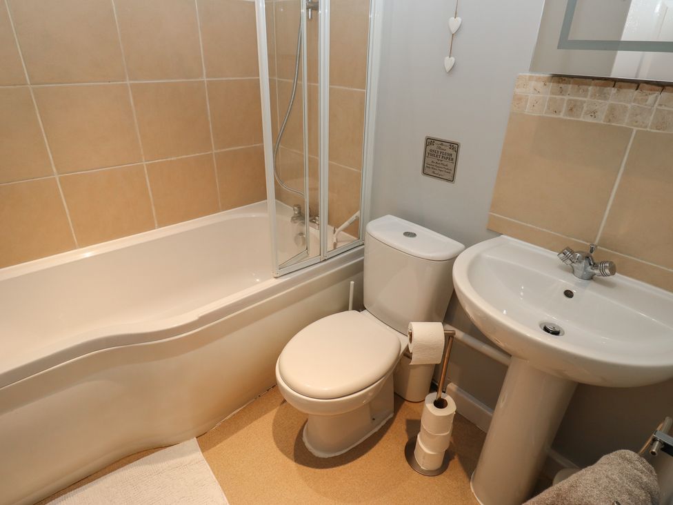 A bathroom with a bathtub, shower, toilet, and sink at Riverview Cottage in Holmfirth