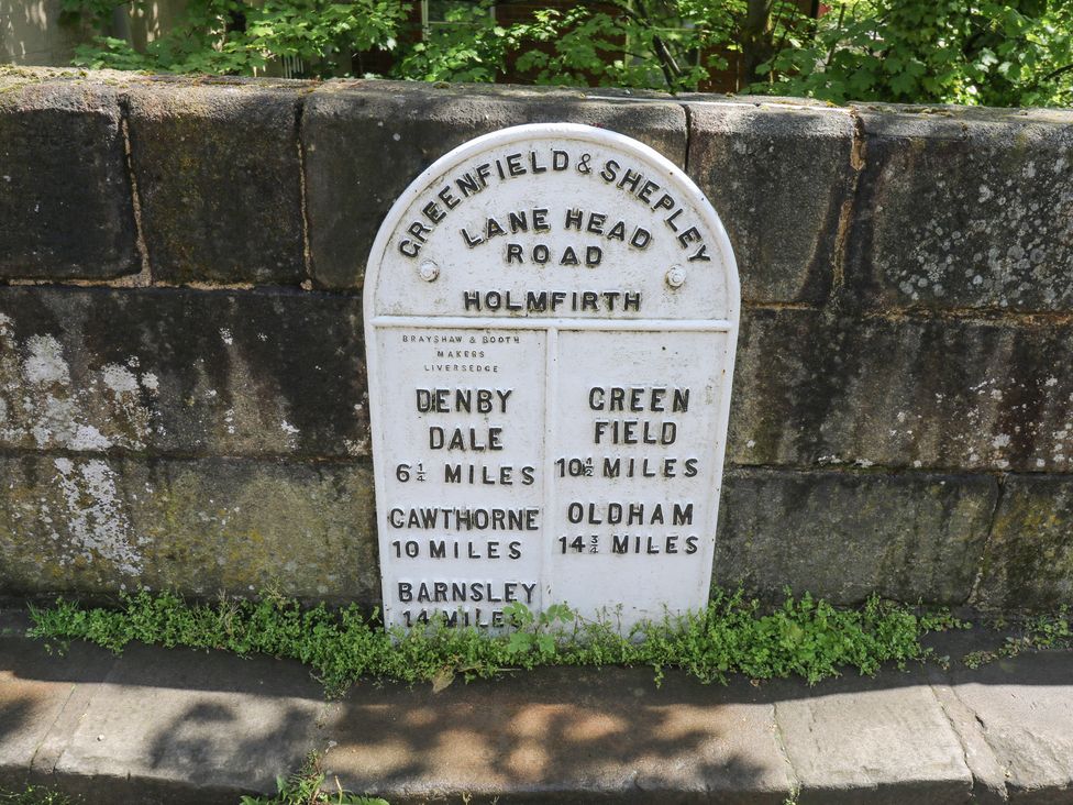 A road sign indicating distances to various locations in Holmfirth