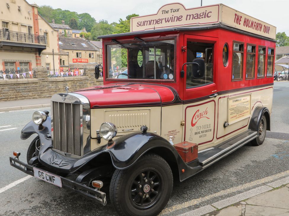 A vintage bus with advertising on the side at Riverview Cottage Holmfirth