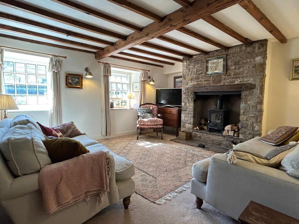 A living room with a fireplace and sofa at Tarn House in Hawes