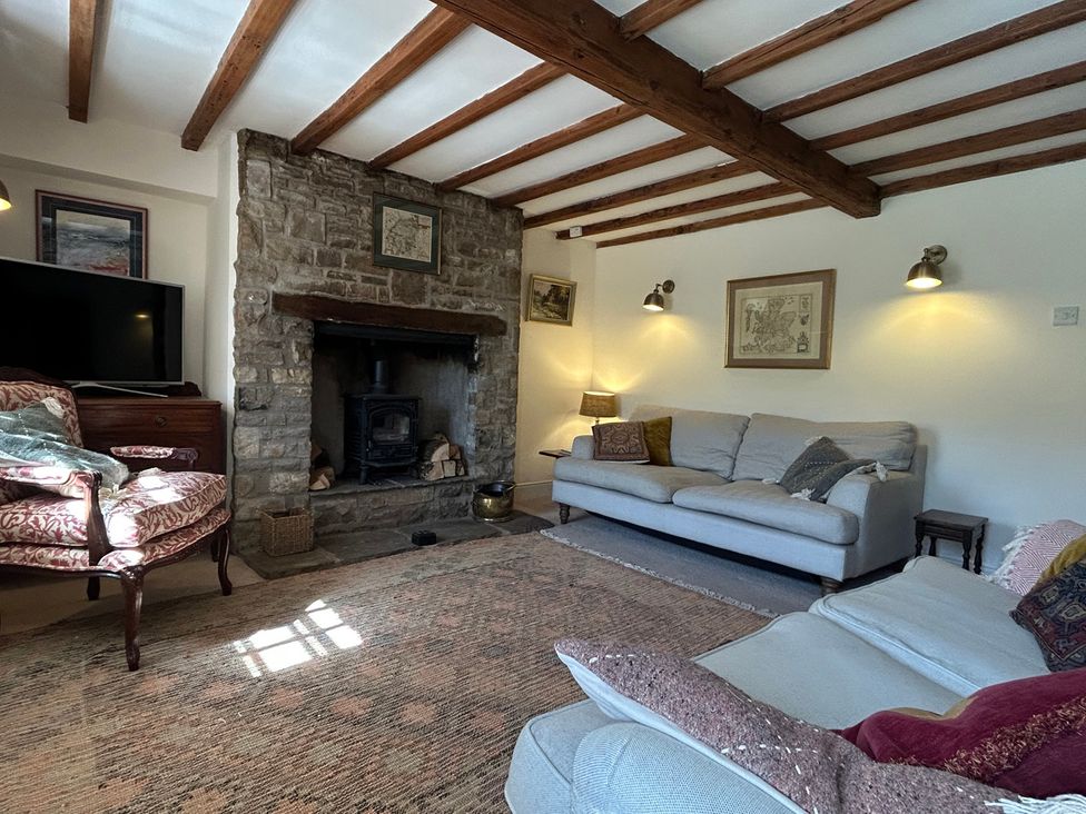 A living room with a fireplace and furniture at Tarn House in Hawes