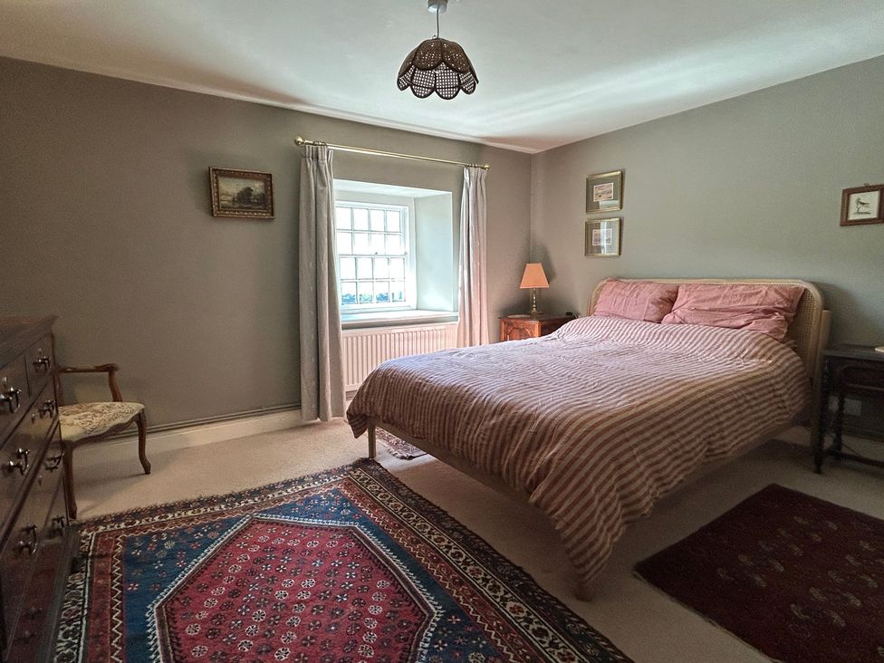 A bedroom with a bed and nightstand at Tarn House in Hawes