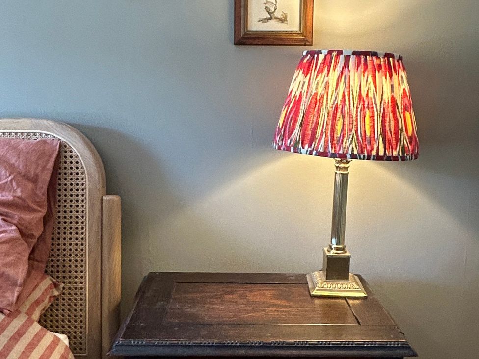 A bedroom with a bedside table and lamp at Tarn House in Hawes