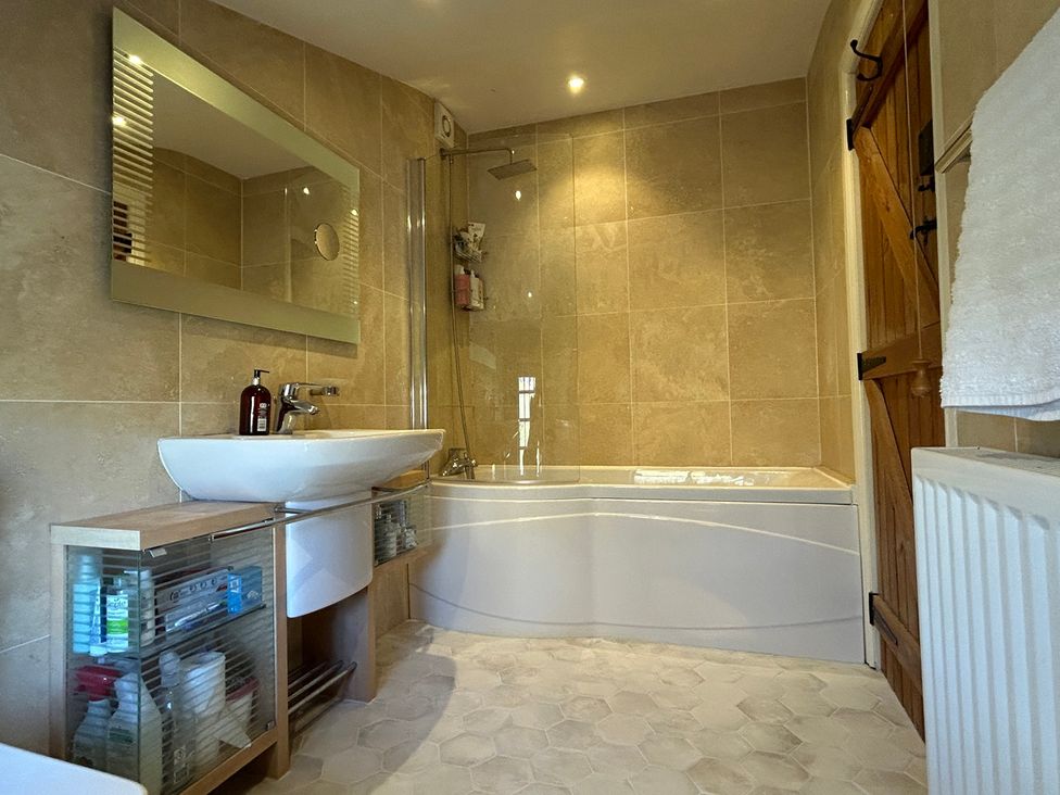 A bathroom with a shower and bathtub at Tarn House in Hawes