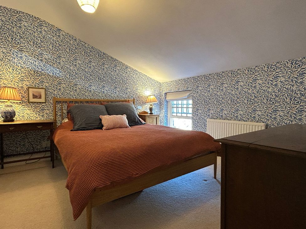 A bedroom with a bed nightstands and table lamps at Tarn House in Hawes